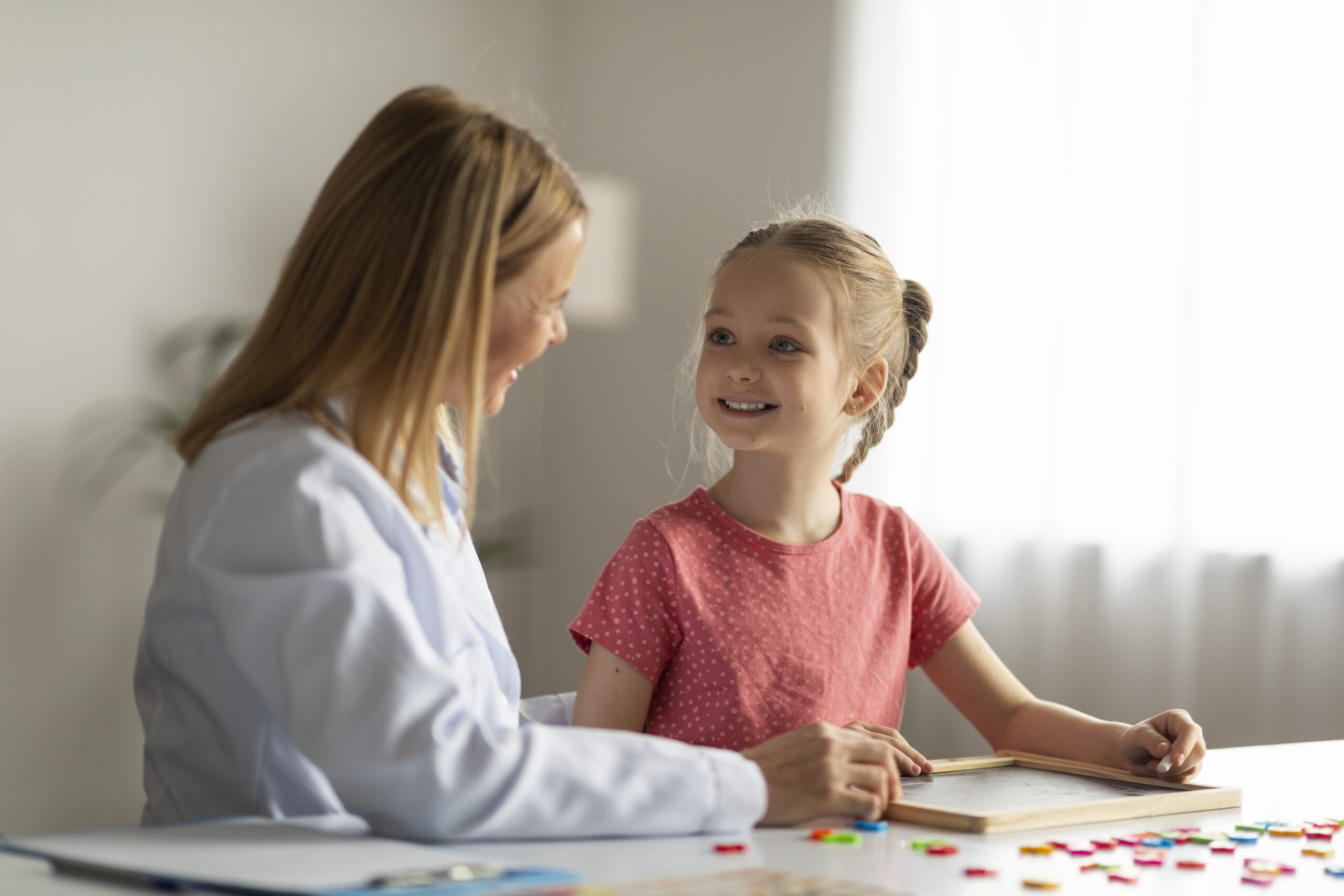 Little Girl Looking At Oral Myofunctional Therapist During an OMT Appointment In Office