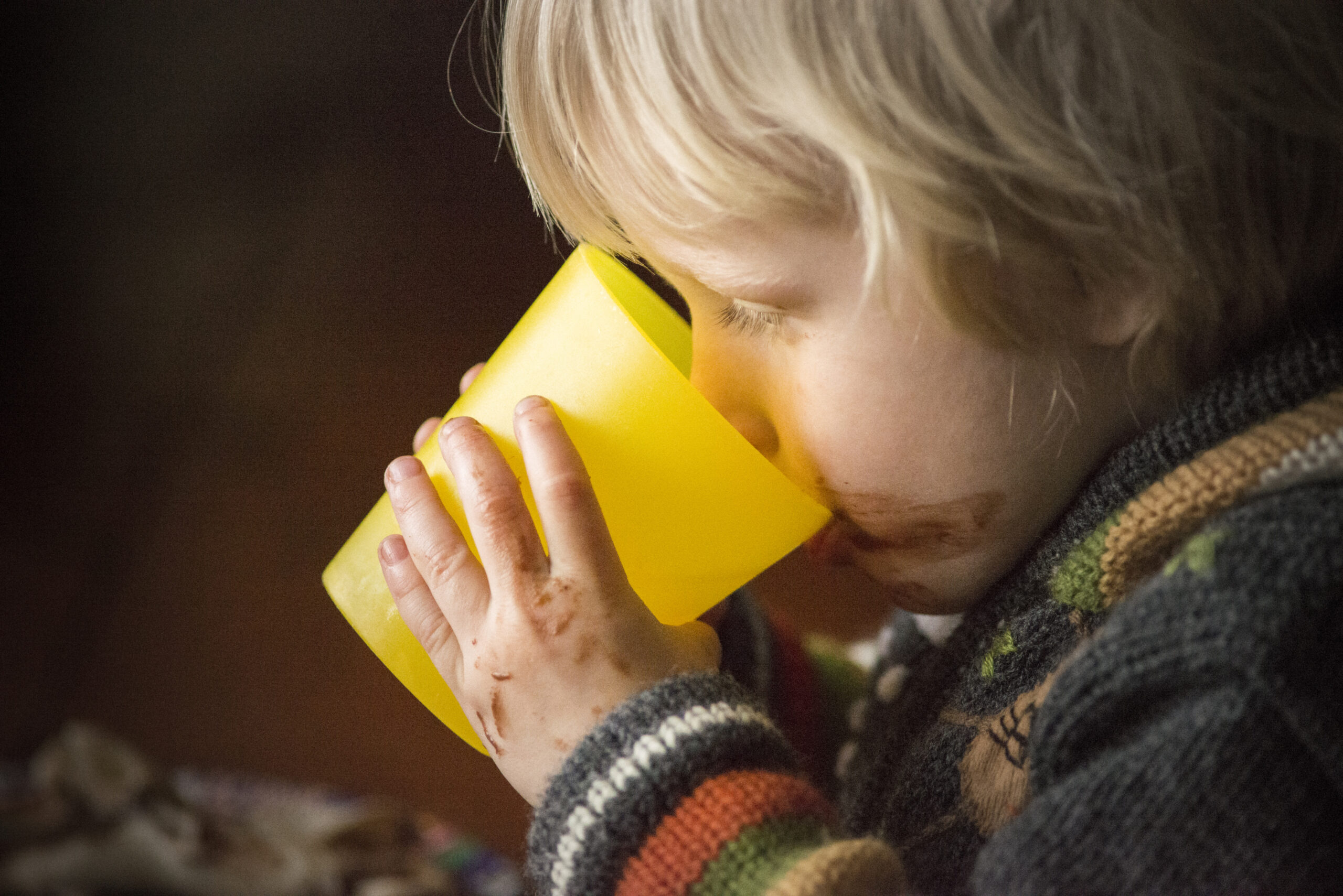 Portrait of young boy drinking water even though he has problems swallowing