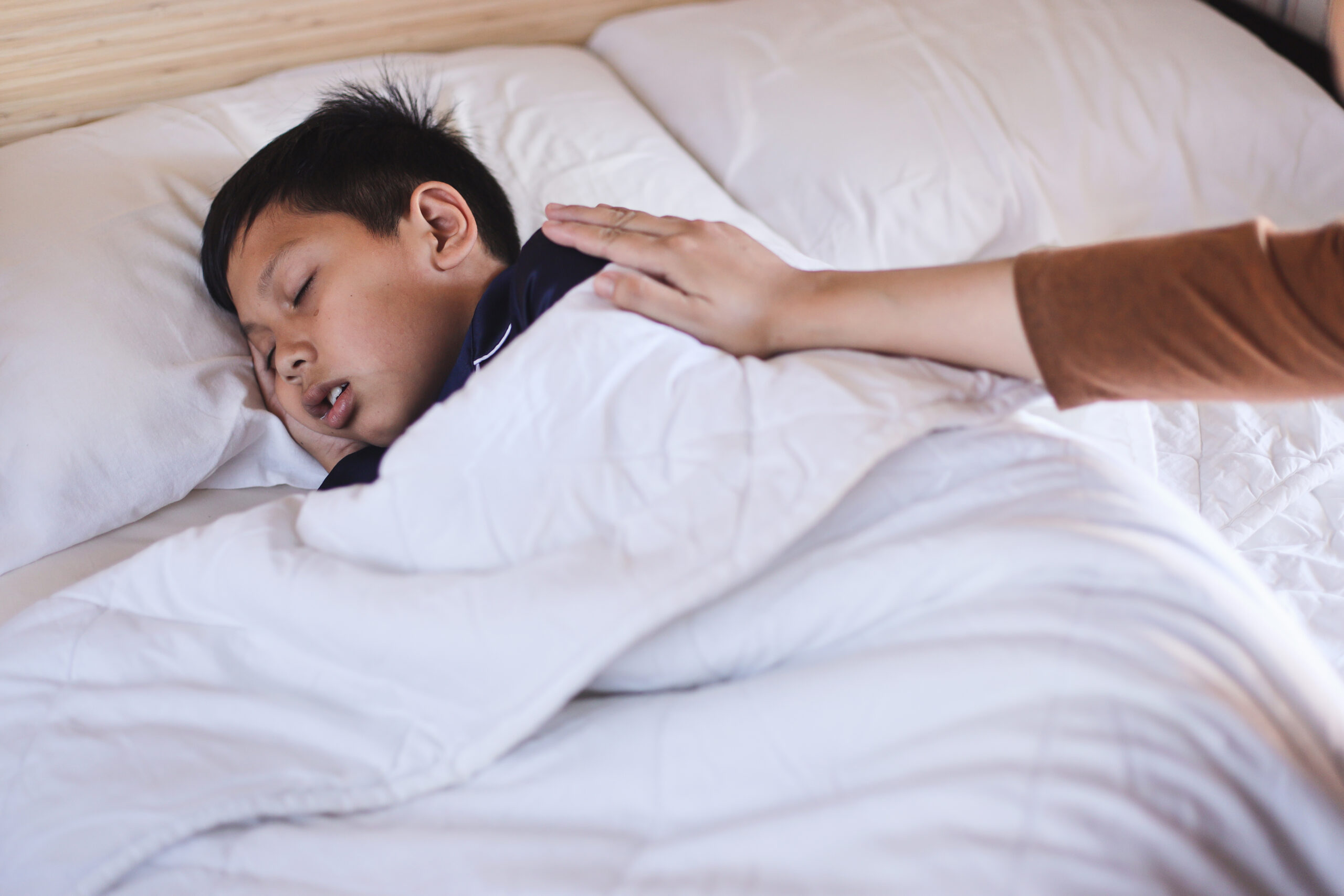 A photo of a child snoring and their parent showing concern